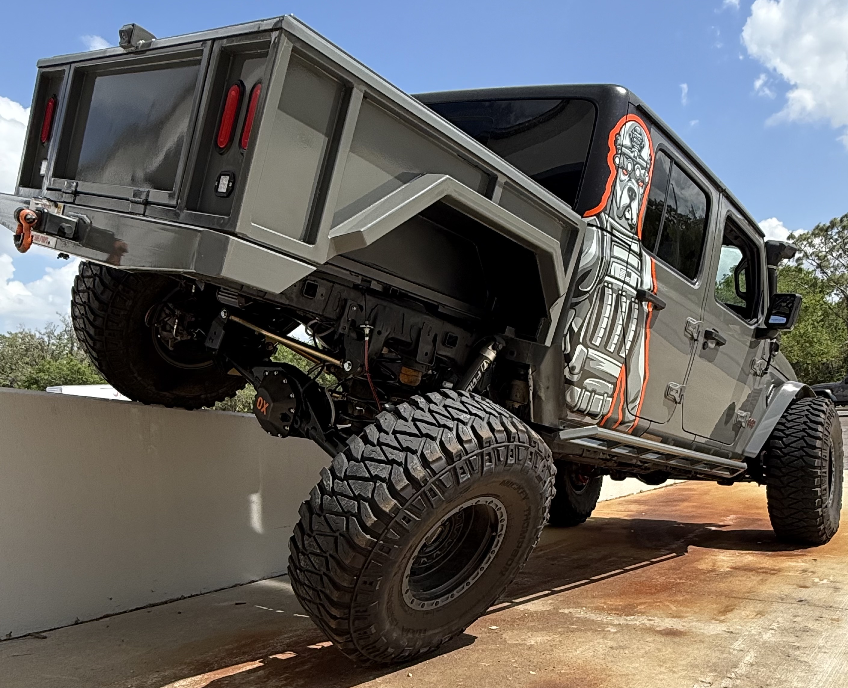War Dog M1 bed flex test - Jeep Gladiator on concrete barrier showing suspension articulation